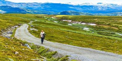 Traveler young hiker walks along hiking trail Rondane National Park Norway. photo