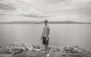 Young male model with sunglasses at Novi Vinodolski Croatia landscape. photo