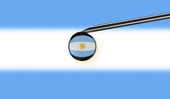 Vaccine syringe with drop on needle against national flag of Argentina background. Medical concept vaccination. Coronavirus Sars-Cov-2 pandemic protection. National safety idea. photo