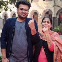 New Delhi, India - December 04 2022 - Unidentified people showing their ink-marked fingers after casting votes in front of polling booth of east Delhi area for MCD local body Elections 2022 photo