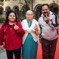 New Delhi, India - December 04 2022 - Unidentified people showing their ink-marked fingers after casting votes in front of polling booth of east Delhi area for MCD local body Elections 2022 photo