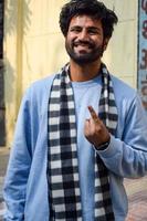 New Delhi, India - December 04 2022 - Unidentified people showing their ink-marked fingers after casting votes in front of polling booth of east Delhi area for MCD local body Elections 2022 photo