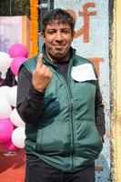 New Delhi, India - December 04 2022 - Unidentified people showing their ink-marked fingers after casting votes in front of polling booth of east Delhi area for MCD local body Elections 2022 photo