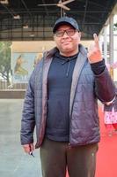 New Delhi, India - December 04 2022 - Unidentified people showing their ink-marked fingers after casting votes in front of polling booth of east Delhi area for MCD local body Elections 2022 photo