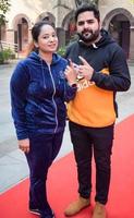 New Delhi, India - December 04 2022 - Unidentified people showing their ink-marked fingers after casting votes in front of polling booth of east Delhi area for MCD local body Elections 2022 photo