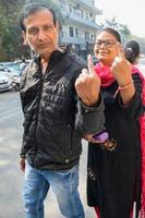 New Delhi, India - December 04 2022 - Unidentified people showing their ink-marked fingers after casting votes in front of polling booth of east Delhi area for MCD local body Elections 2022 photo