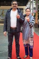 New Delhi, India - December 04 2022 - Unidentified people showing their ink-marked fingers after casting votes in front of polling booth of east Delhi area for MCD local body Elections 2022 photo