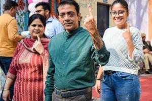 New Delhi, India - December 04 2022 - Unidentified people showing their ink-marked fingers after casting votes in front of polling booth of east Delhi area for MCD local body Elections 2022 photo