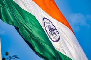 India flag flying high at Connaught Place with pride in blue sky, India flag fluttering, Indian Flag on Independence Day and Republic Day of India, tilt up shot, Waving Indian flag, Har Ghar Tiranga photo