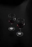 dos copas de vino tinto aisladas sobre fondo negro foto