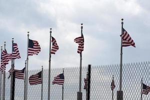 Waving usa flags behind fence grid photo