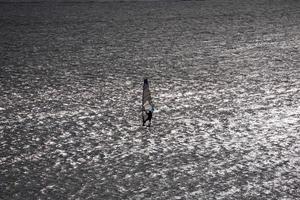 silueta de windsurf en la luz de fondo foto