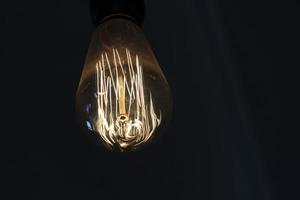 Lamp light bulb detail isolated on black photo