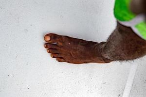 Detalle de pies de migrantes de hombre negro sin zapatos en el barco foto