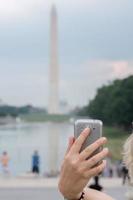 selfie remoto en el teléfono celular en el obelisco del monumento a washington foto