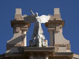 victory fascism angel statue on the top of old building photo