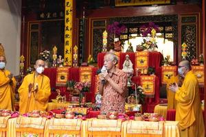 Bandung City, Indonesia, 2022 - The congregation and the monks standing together while praying at the altar to respect the god photo