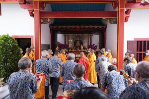 Bandung City, Indonesia, 2022 - Buddhist People pray together with the monks while giving the offering in front of the altar photo
