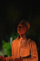 A Muslim man lighten up the campsite with the fire torch in his hands photo