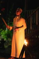 A Muslim man standing with the fire torch in her hand at the front of the village photo