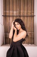 Portrait of an Asian woman with black hair being lonely with the wooden window photo