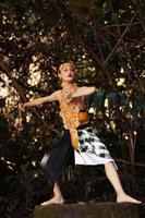 A Traditional dancer with golden clothes and a golden crown posing bravely in the jungle photo