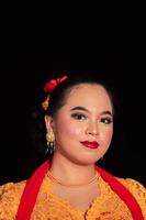 Sundanese woman wearing a short dress and traditional yellow dress with red scarf and makeup after the dance performance photo