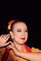 Exotic Javanese woman wearing beautiful makeup with red lips while wearing a traditional yellow costume and red scarf photo