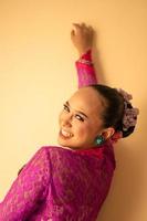 Balinese mother wearing a pink dress called kebaya and make-up before praying photo