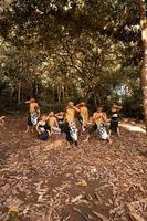 Javanese dance in golden costumes while wearing a makeup pose together nearing the brown leaves photo