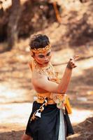Javanese mane dancing in shirtless while wearing a golden crown and golden accessories photo