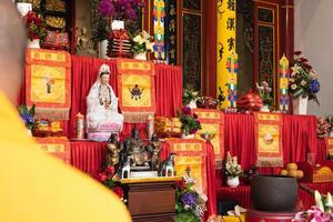 ciudad de bandung, indonesia, 2022 - los monjes en naranja roban de pie en orden mientras rezan al dios en el altar dentro del templo de buda foto