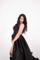 Portrait shoot of Asian woman with black dress poses in black hair photo