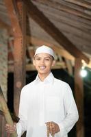 Handsome Islamic man with white Muslim dress in the dark night photo