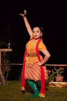 Indonesian women wearing traditional dance costumes called kebaya and pose with dancing moves in the night photo