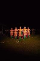 bailarines balineses parados juntos con bufanda roja y trajes naranjas en el escenario después de realizar la danza tradicional foto