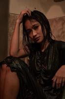 chica asiática caliente y húmeda posa con estilo sensual mientras usa vestidos negros mojados foto