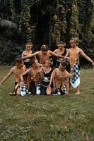 A bunch of Asian people having fun while taking a photo shoot with a golden dance costume in front of the jungle