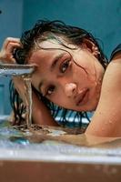 Asian Women hold hear heads near the faucet and water flow from it photo