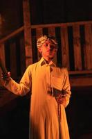 An Arabian man holding a fire torch in the front of a wooden house photo