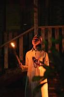 A Muslim man standing with the fire torch in her hand at the front of the village photo