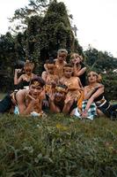 Javanese people with traditional dance costumes laying down on the grass together during the photo shoot