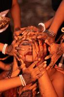 Sad Man Faces covered up by a lot of hands with henna tattoos while wearing a gold crown photo