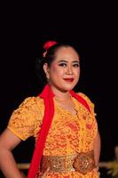 Exotic Indonesian women with red lips and makeup while wearing an orange dress and red scarf photo