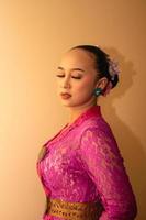 Balinese bride wearing the pink wedding dress before the ceremony has started photo