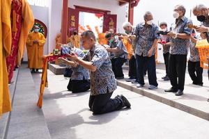 Bandung City, Indonesia, 2022 - Buddhist People pray together with the monks while giving the offering in front of the altar photo