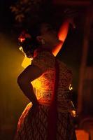 Balinese women wearing cultural clothes while posing in front of the lighting with dancing movements photo