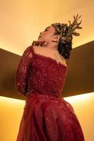 Asian woman in red dress posing with a gold crown on her head photo