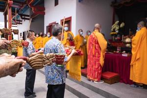 Bandung City, Indonesia, 2022 - Buddhist community praying together with the monks in front of the altar photo