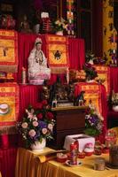 ciudad de bandung, indonesia, 2022 - las ofrendas como comida y velas en la parte superior de la mesa budista roja durante la oración de los monjes foto